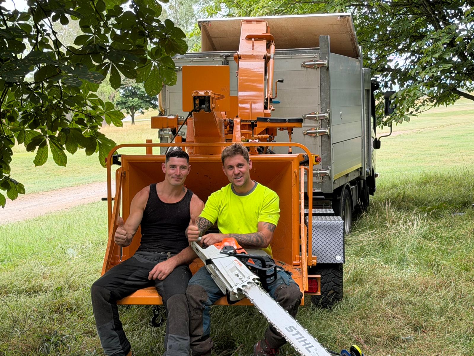Father-and-son arborist team on a woodchipper at a Hertfordshire job